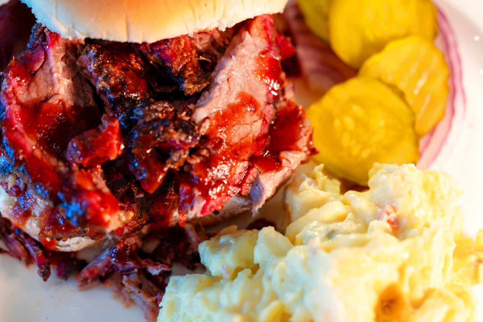 A pulled pork sandwich with mashed potatoes