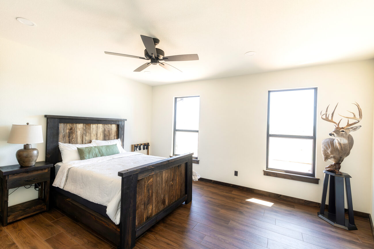 A bedroom with a window and antler mount