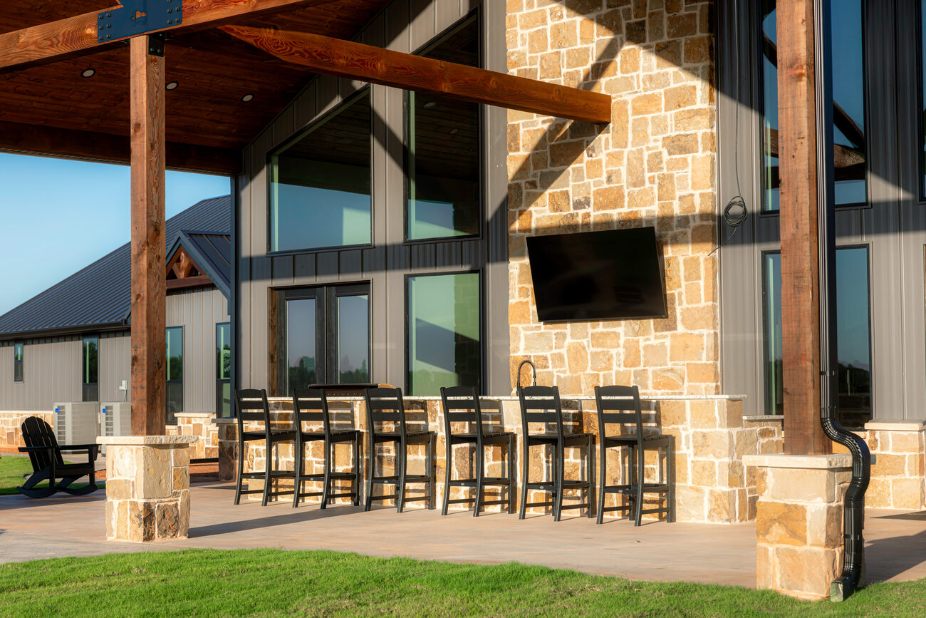 The covered stone-and-timber patio with bar seating at The Lodge at Dry Creek