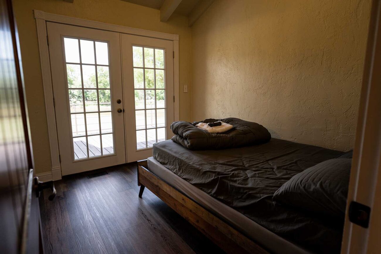 A bedroom with french doors at Pecan Creek